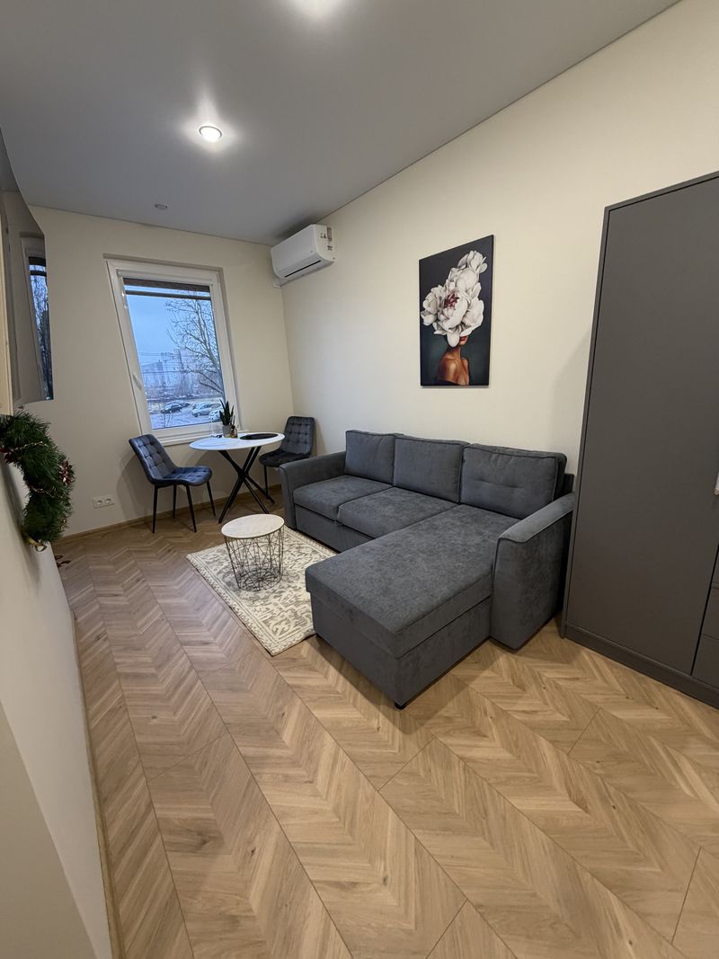 Kambarys po remonto: parketlentės eglute, kampinė sofa